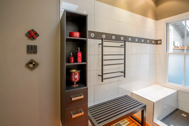 Bright bathroom with white tiles, built-in storage and decorative accents