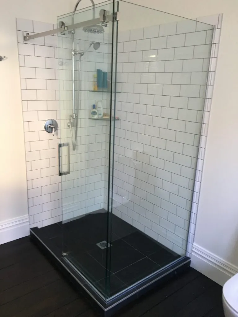 Walk-in shower with white subway tile and frameless glass enclosure