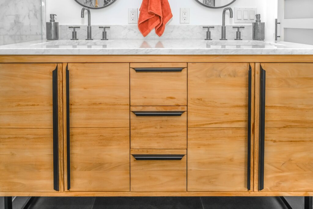Wooden faced bathroom sink storage. Marble counter top.