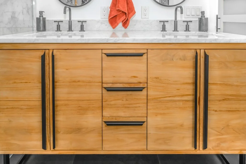 Wooden faced bathroom sink storage. Marble counter top.